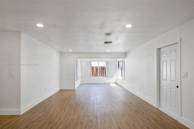 spare room with visible vents, recessed lighting, baseboards, and wood finished floors