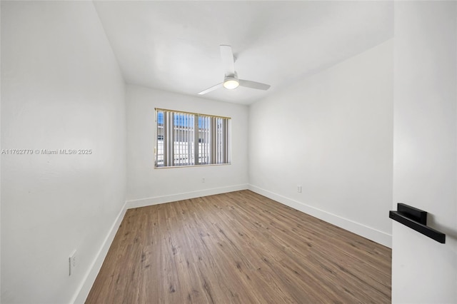 empty room featuring wood finished floors, baseboards, and ceiling fan