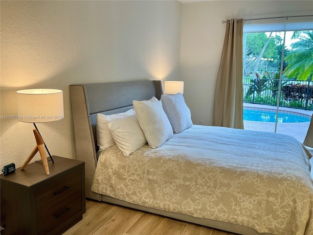 bedroom featuring light wood-style flooring and access to exterior