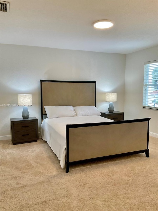 bedroom with visible vents, light colored carpet, and baseboards