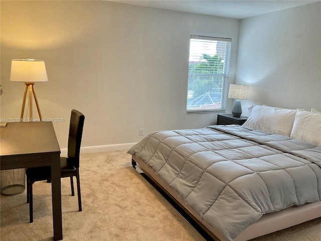 bedroom featuring light colored carpet and baseboards