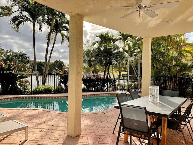 view of pool with outdoor dining space, a ceiling fan, fence, a fenced in pool, and a patio area