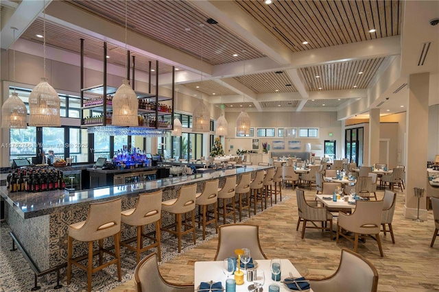 bar featuring beam ceiling, coffered ceiling, a high ceiling, and wood finished floors