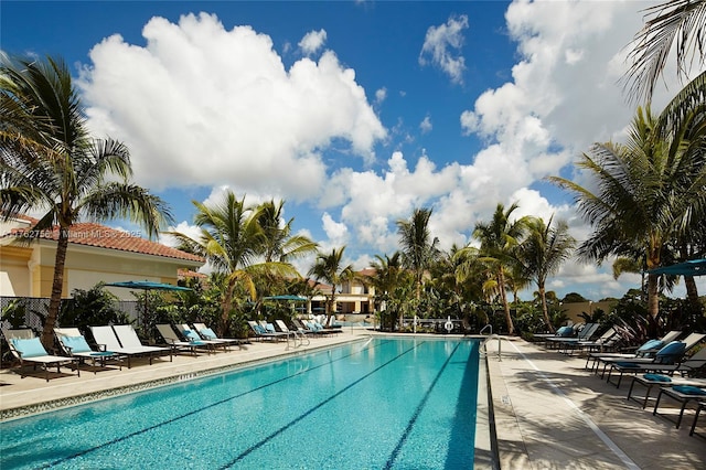 community pool with fence and a patio area