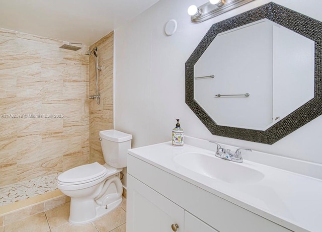 full bathroom with tile patterned flooring, tiled shower, toilet, and vanity