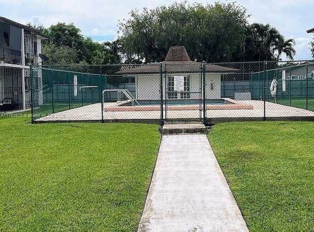 exterior space with a swimming pool, a lawn, and fence