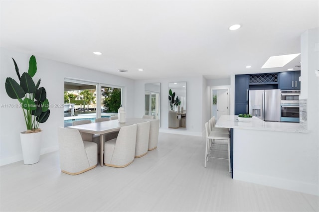 dining space with a skylight, recessed lighting, and baseboards