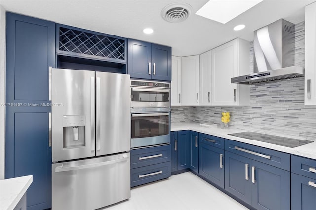 kitchen with visible vents, stainless steel appliances, blue cabinets, and wall chimney range hood