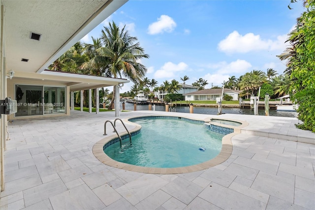 view of pool featuring a patio area, a water view, a pool with connected hot tub, and a boat dock