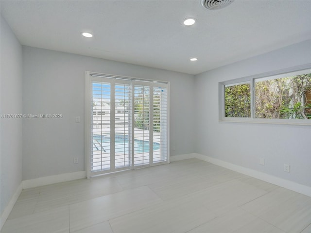 empty room featuring visible vents, recessed lighting, and baseboards