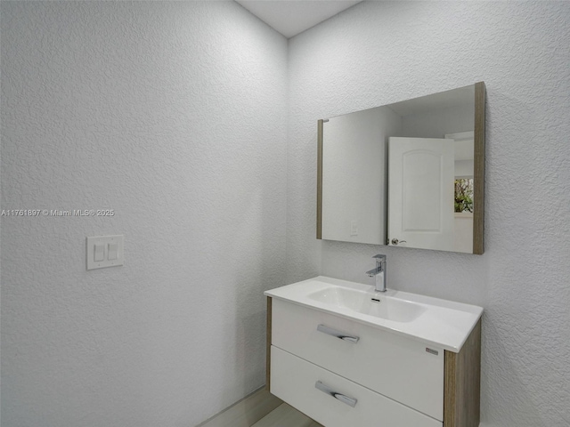 bathroom with vanity and a textured wall