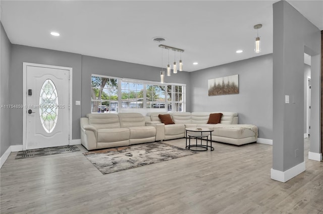 living area featuring recessed lighting, visible vents, baseboards, and wood finished floors