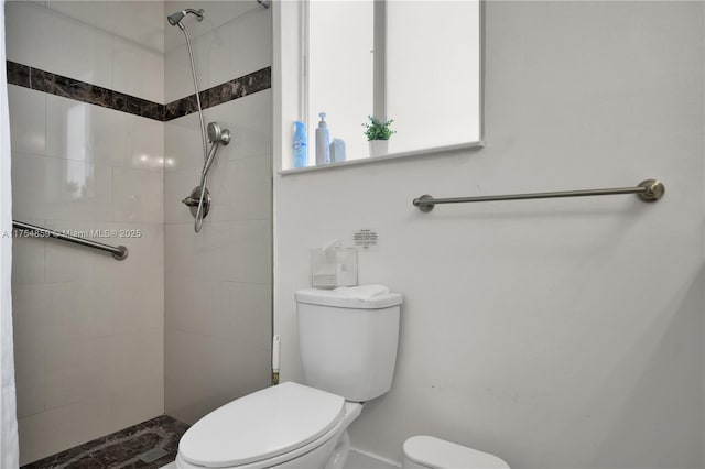 bathroom featuring toilet and tiled shower