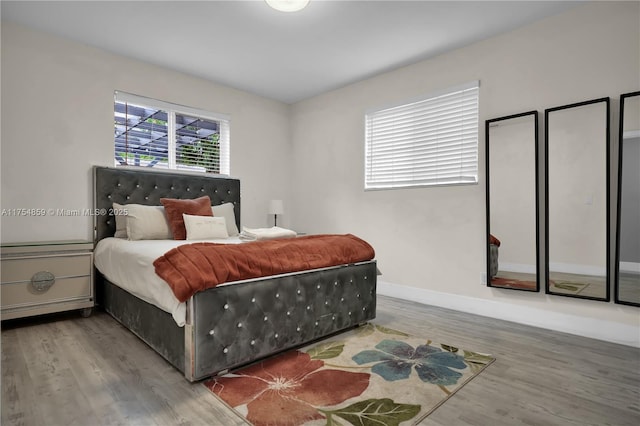 bedroom with baseboards and wood finished floors