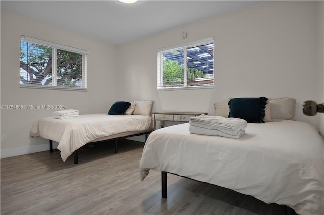 bedroom with light wood-style flooring and baseboards