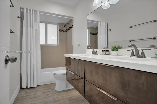 full bathroom with double vanity, wood finished floors, shower / tub combo with curtain, and a sink