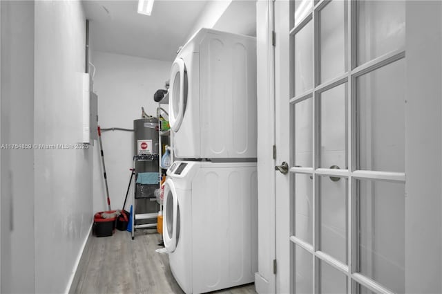 laundry room with laundry area, wood finished floors, and stacked washer / drying machine