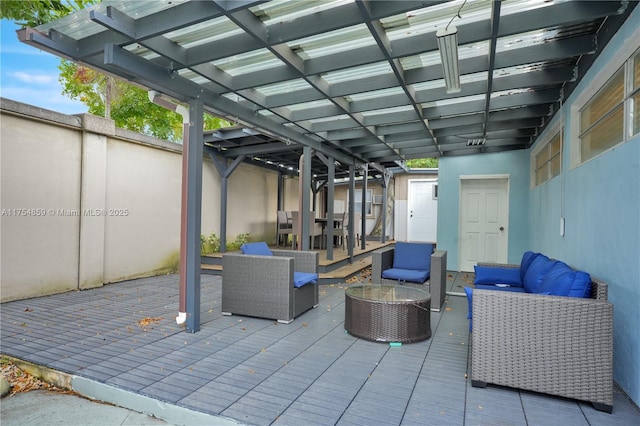 view of patio with an outdoor living space, a deck, and fence