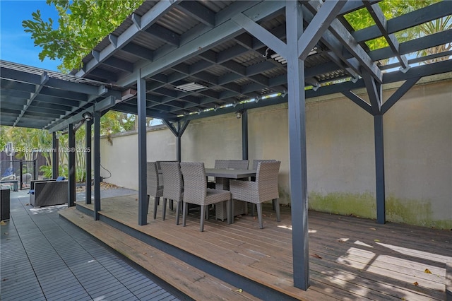 wooden terrace featuring outdoor dining area and a pergola