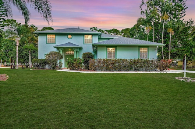 view of front of house with stucco siding and a front yard