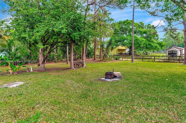 view of yard featuring a fire pit and fence