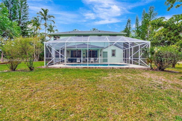 back of property with an outdoor pool, a lawn, and a lanai