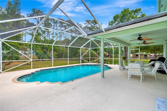 pool with a patio, outdoor dining area, ceiling fan, a lanai, and a lawn