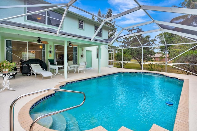 outdoor pool with a lanai, a ceiling fan, and a patio area