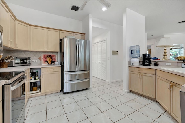 kitchen featuring visible vents, light brown cabinetry, backsplash, appliances with stainless steel finishes, and light countertops