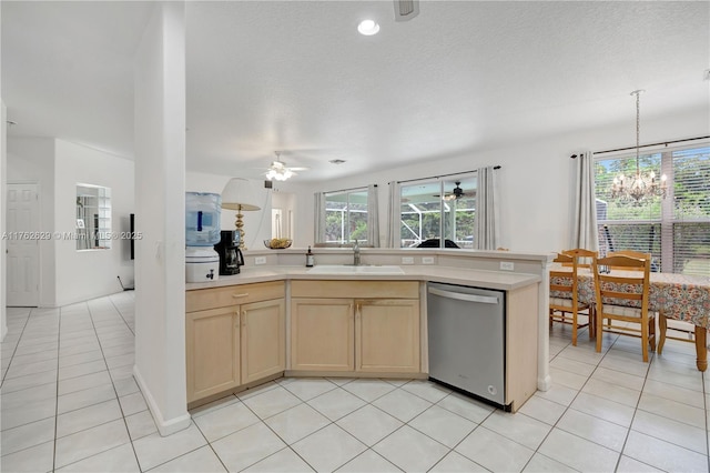 kitchen featuring a sink, stainless steel dishwasher, light countertops, and light tile patterned floors