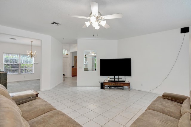 living room featuring light tile patterned flooring, ceiling fan with notable chandelier, and visible vents