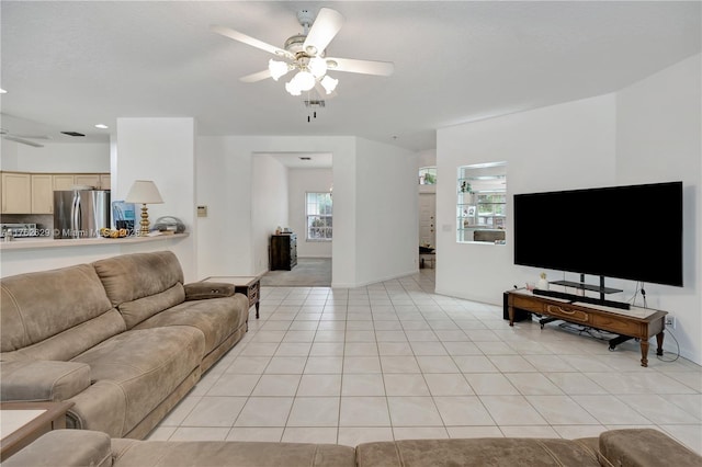 living room featuring light tile patterned floors, visible vents, and ceiling fan