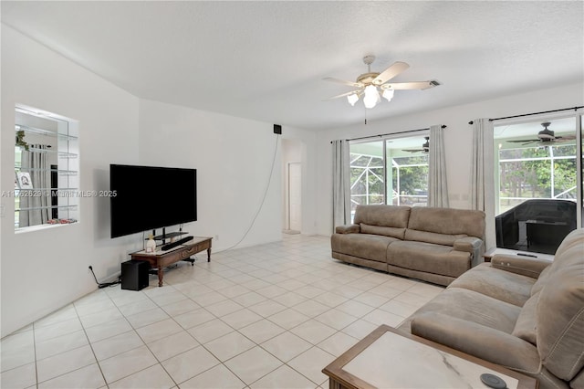 living room with a textured ceiling, light tile patterned floors, and ceiling fan