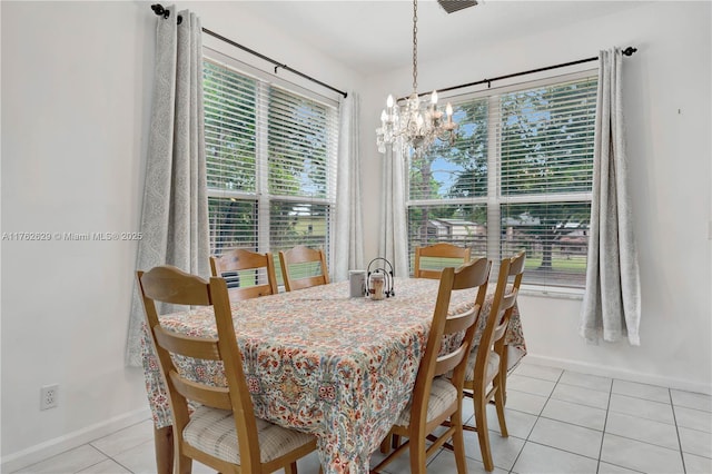 dining space featuring light tile patterned floors, baseboards, and a notable chandelier