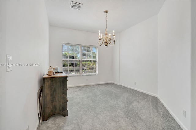 empty room with visible vents, baseboards, light colored carpet, and a chandelier