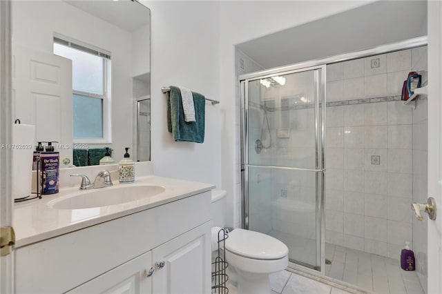 bathroom featuring vanity, a shower stall, and toilet