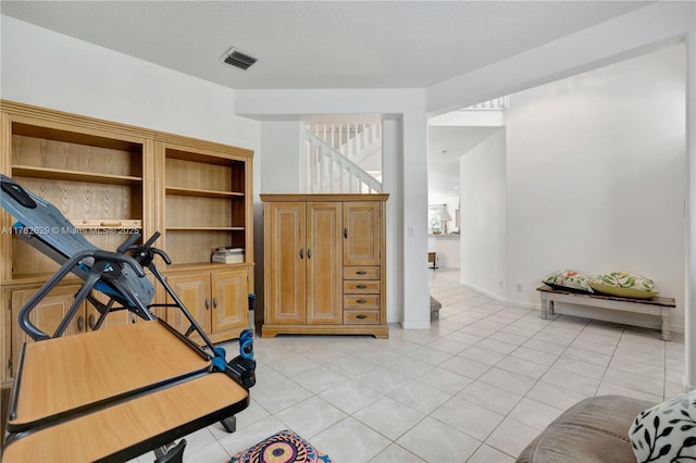 workout area featuring light tile patterned floors, baseboards, and visible vents