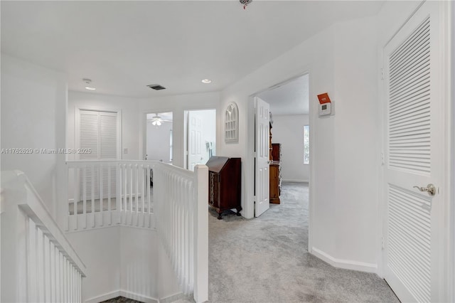 corridor with recessed lighting, visible vents, light colored carpet, and baseboards