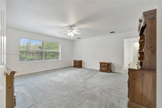 unfurnished bedroom with baseboards, visible vents, carpet floors, ceiling fan, and a textured ceiling