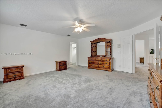 unfurnished bedroom with carpet flooring, a ceiling fan, visible vents, and a textured ceiling