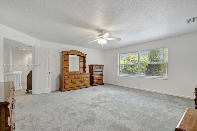 bedroom with a ceiling fan, carpet, visible vents, baseboards, and a textured ceiling