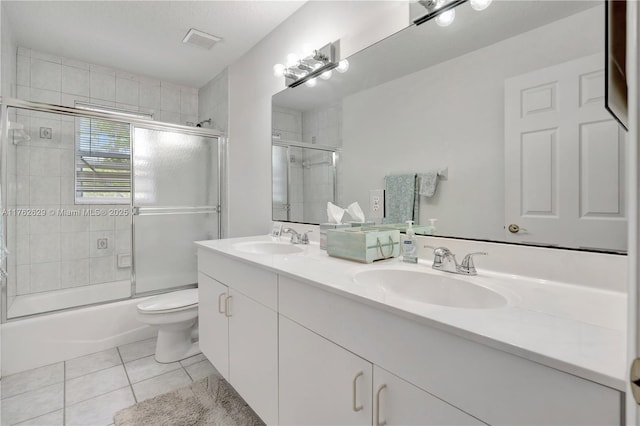 bathroom featuring a sink, bath / shower combo with glass door, double vanity, and tile patterned flooring