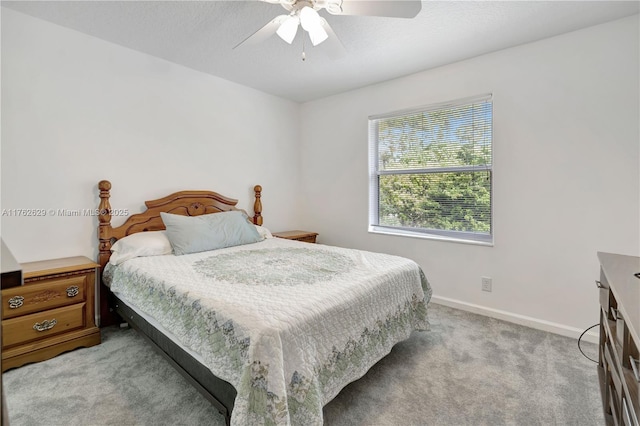 bedroom featuring a textured ceiling, a ceiling fan, baseboards, and light carpet