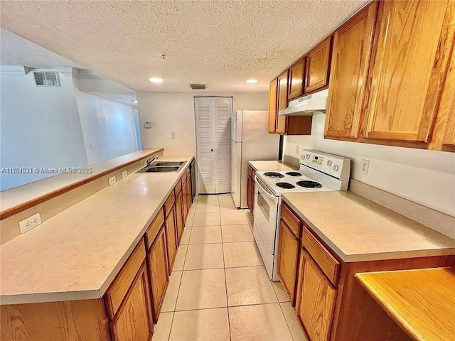 kitchen with white appliances, brown cabinets, under cabinet range hood, and a sink