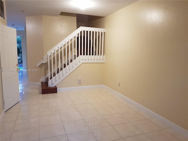 staircase with tile patterned floors, visible vents, and baseboards