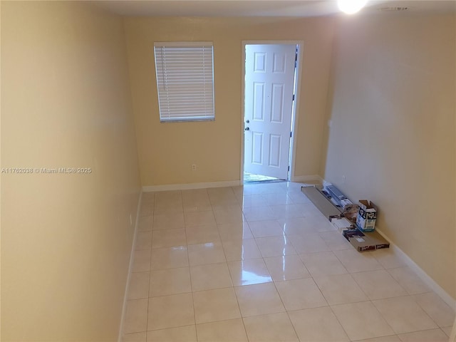 unfurnished room featuring light tile patterned floors and baseboards