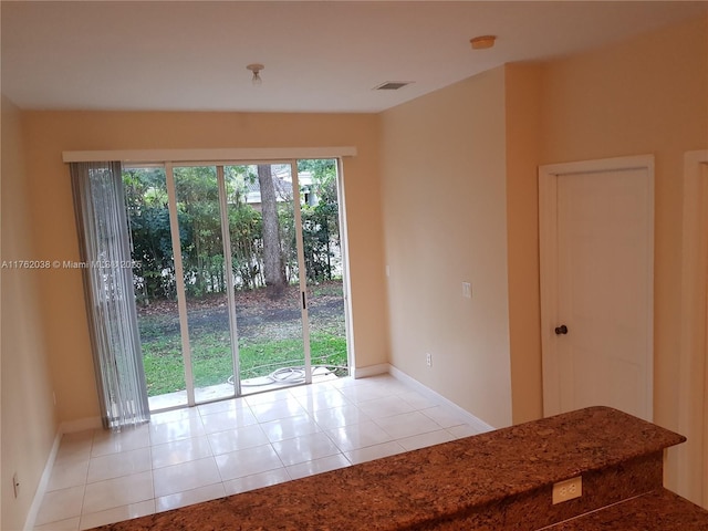 interior space with light tile patterned floors, visible vents, and baseboards