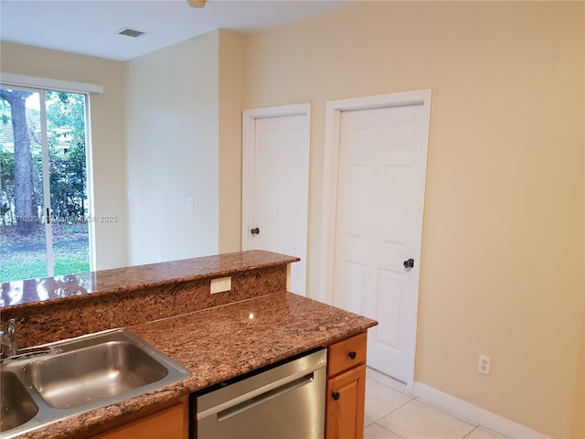 kitchen with visible vents, light tile patterned flooring, stone countertops, a sink, and stainless steel dishwasher