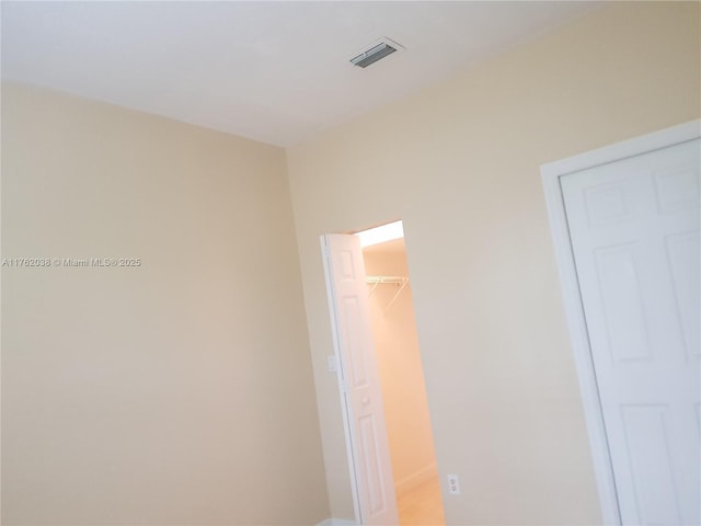 unfurnished bedroom featuring a spacious closet, visible vents, and a closet