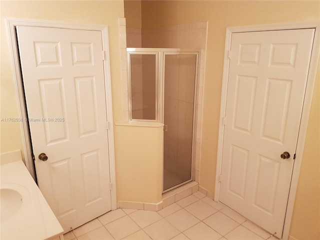 bathroom featuring tile patterned floors, a stall shower, vanity, and baseboards